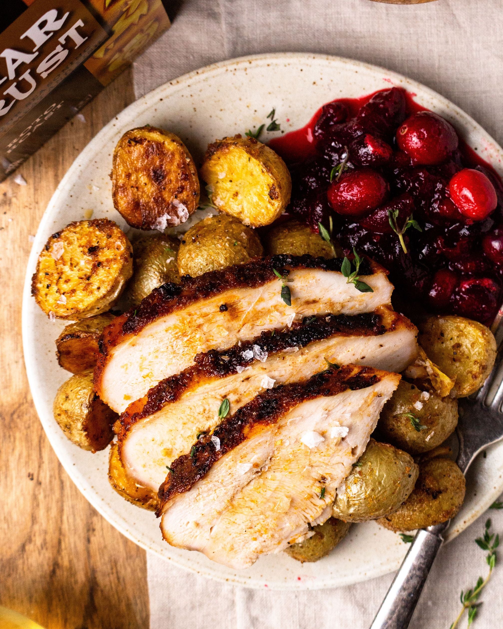 Char Crust® Roto (Rotisserie) Roast rub is used on turkey in this picture with potatoes and cranberries for a Thanksgiving meal. Char Crust Rotisserie Roast is a great turkey rub, chicken rub or steak rub.